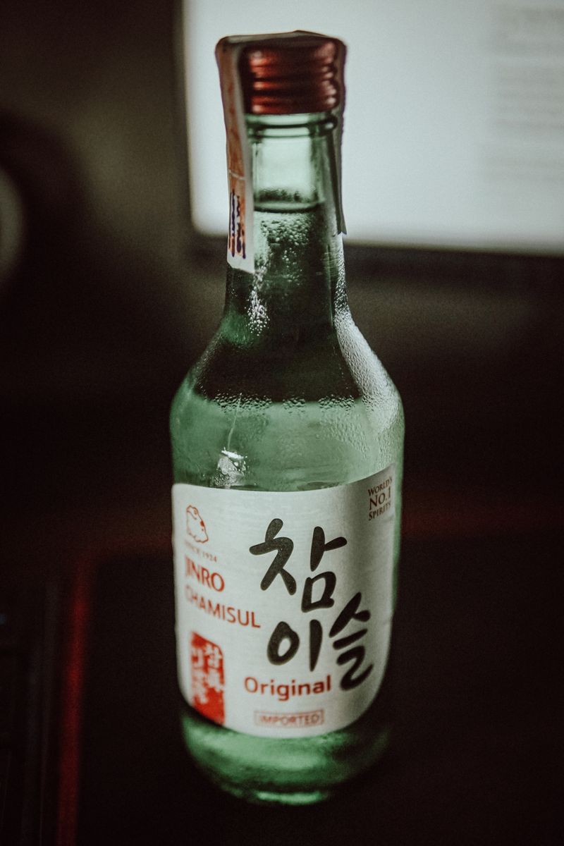 어두운 조명 아래 테이블에 놓인 소주 한 병